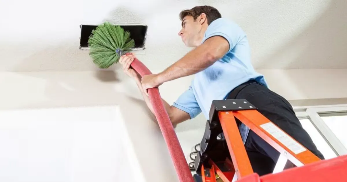 Technician agitating supply ducts during a cleaning